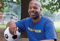 Man resting his arm on a football